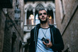 © BublikHaus - Young erasmus exchange student explores new city and culture of Barcelona spain, walks around tourist attractions with vintage analog camera. Handsome hipster man discovers