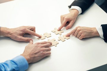 business cooperation concept - businessmen's  connecting puzzle pieces