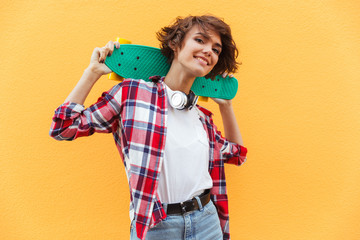 Sticker - Happy pretty teenage girl holding skateboard on her shoulders