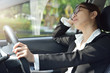 © eggeeggjiew - Business woman sleeping while driving a car.
