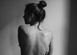 © Jesse Morrow/Stocksy - young woman with bare back towards camera intimate studio black and white