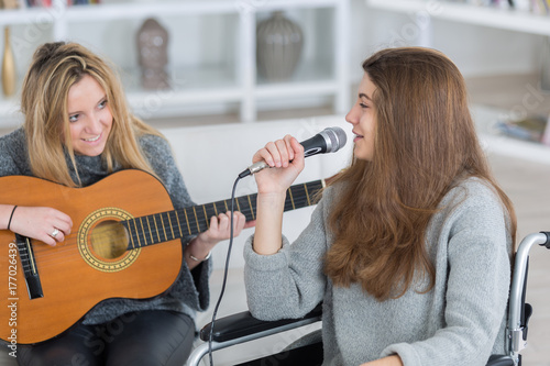 Zdjęcie XXL młoda kobieta ze śpiewem, podczas gdy jej przyjaciółka gra na gitarze