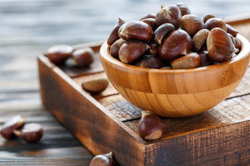 Wall Mural - Raw chestnuts in a wooden bowl.