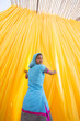© hughsitton/Stocksy - Rajasthani woman drying newly dyed fabric.  India.