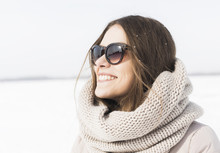 Happy Young Woman With Sunglasses On The White Snow Background