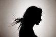 © Trinette Reed/Stocksy - Silhouette of woman with hair blowing in the studio.