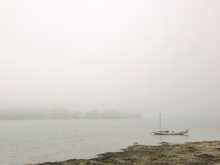 Anchored Sailboat On Foggy Lake