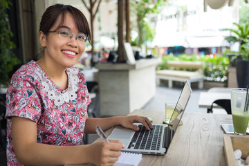 Cute student using laptop and smiling