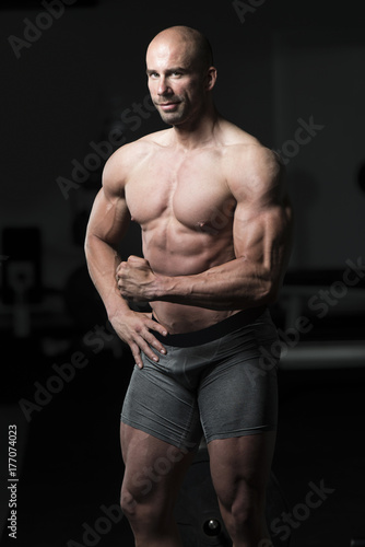 Plakat Mężczyzna w Gym Pokazuje Jego Well - wyszkolonego ciało