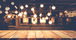 Wood table top on blurred of counter cafe shop with light bulb background.For montage product display or design key visual
