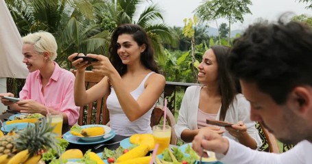 Sticker - Girls Taking Photos Of Healthy Vegetarian Food On Cell Smart Phone, Friends Eating Talk Sitting On Tropical Terrace Slow Motion 60