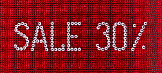 Sticker - Word SALE is made rhinestones crystal color on a red canvas background.