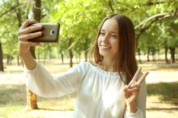 girl is making a selfie in a park