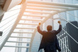 © Love You Stock - King of the world, Successful businessman raising hand in front of the smart building. business success concept.