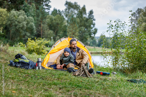 Plakat ojciec i syn w camping na jeziorze