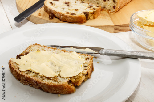 Zdjęcie XXL chleb z rodzynkami z masłem na białym talerzu