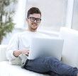 © ASDF - successful young male freelancer working on laptop at home.