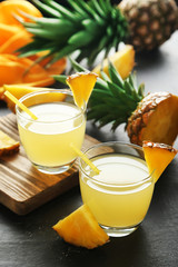 Wall Mural - Glasses of pineapple juice on a black wooden table