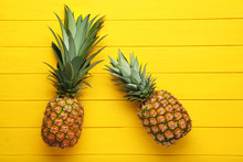 Ripe Pineapples On Yellow Wooden Table