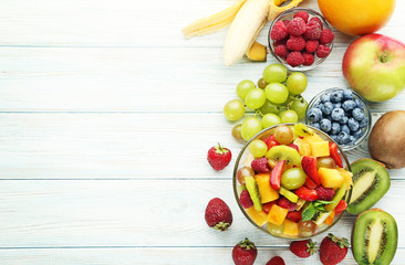 Canvas Print - Fruit salad in bowl on white wooden table