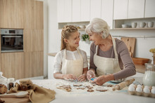 Joyful Grandmother Teaching Kid How To Make Cookies