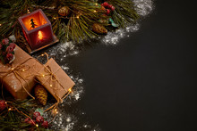 Christmas Gifts And Red Candlestick Near Green Spruce Branch On A Black Background. Christmas Background. Top View.