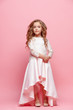 © master1305 - Full length of beautiful little girl in dress standing and posing over white background