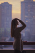 © Maja Topcagic/Stocksy - Young beautiful woman with blue eyes and long brown hair outside the city at sunset