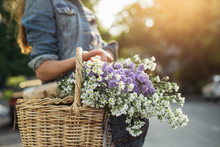 Woman Holding A Wooden Basket Full Of Flowers
