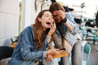 © Drobot Dean - Two overjoyed female best friends in jeans wear laughing while sitting at cafeteria