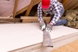 © artursfoto - worker cutting plasterboard with construction knife. Attic renovation