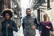 © BONNINSTUDIO/Stocksy - Group of young friends running on Barcelona streets.