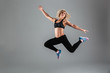 © Drobot Dean - Full length portrait of a smiling muscular adult woman jumping