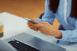 © djile - Women in the office typing a message on the phone focus on hands