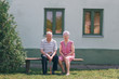 © Jovana Milanko/Stocksy - Senior couple sitting at the bench in front of their house