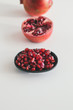 © Jovo Jovanovic/Stocksy - Pomegranate, half pomegranate and pomegranate seeds on white background
