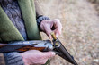 © MartaMC/Stocksy - Old man putting ammunition in a hunting rifle-(loading shotgun)