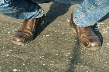 Brown leather man's shoes on squatting legs