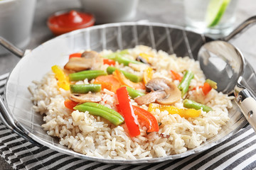 Canvas Print - Brown rice with vegetables and mushrooms in frying pan