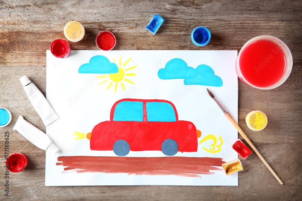 Child's painting of red car on table
