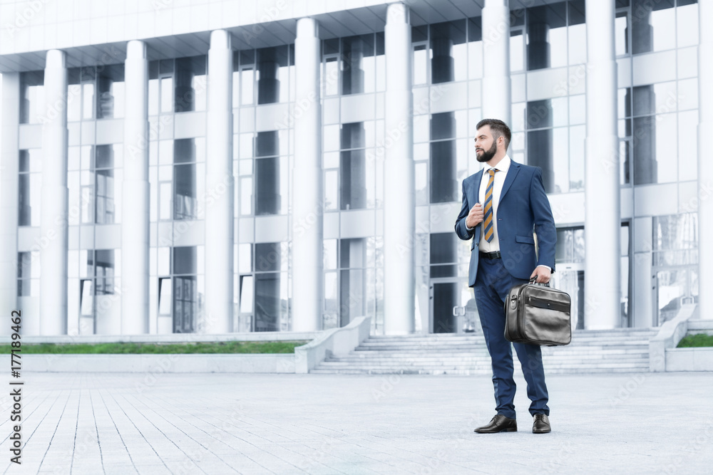 Handsome successful businessman in elegant suit outdoors