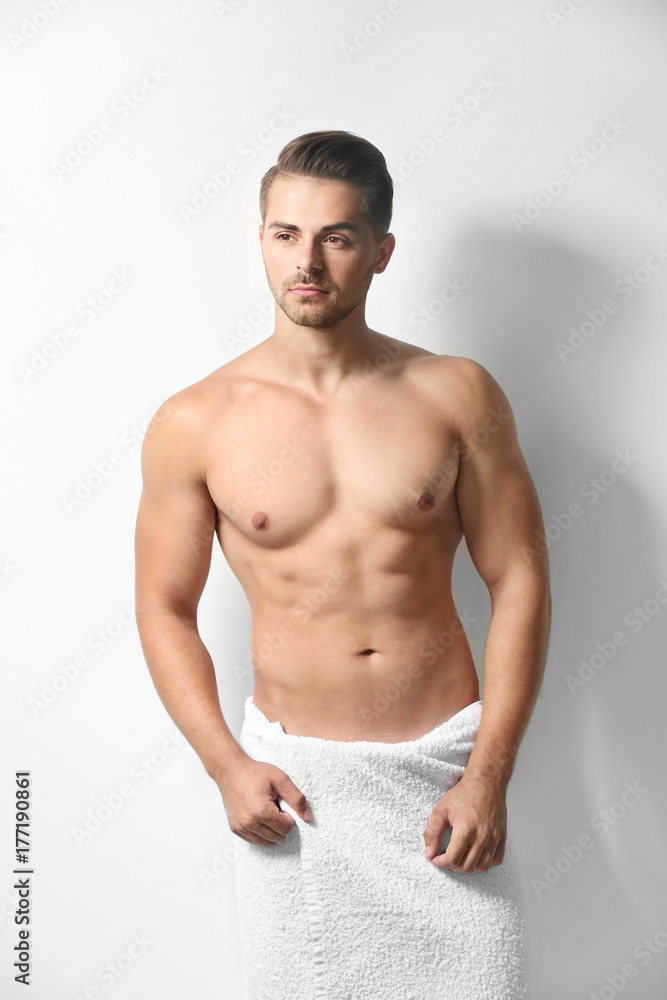 Sexy man wrapped in towel on white background