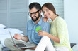 © Africa Studio - Young couple with laptop and credit card at home. Internet shopping concept