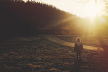 Young Boy Walking Near A Trail During Sunset