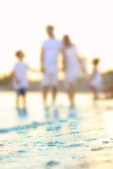 Canvas Print - Blurred view of happy family on sea beach