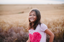 Portrait Of An Adorable Smiling Girl At Wheat Field