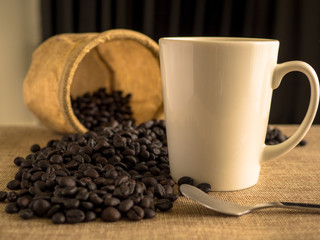 White coffee cup with coffee beans and bag.