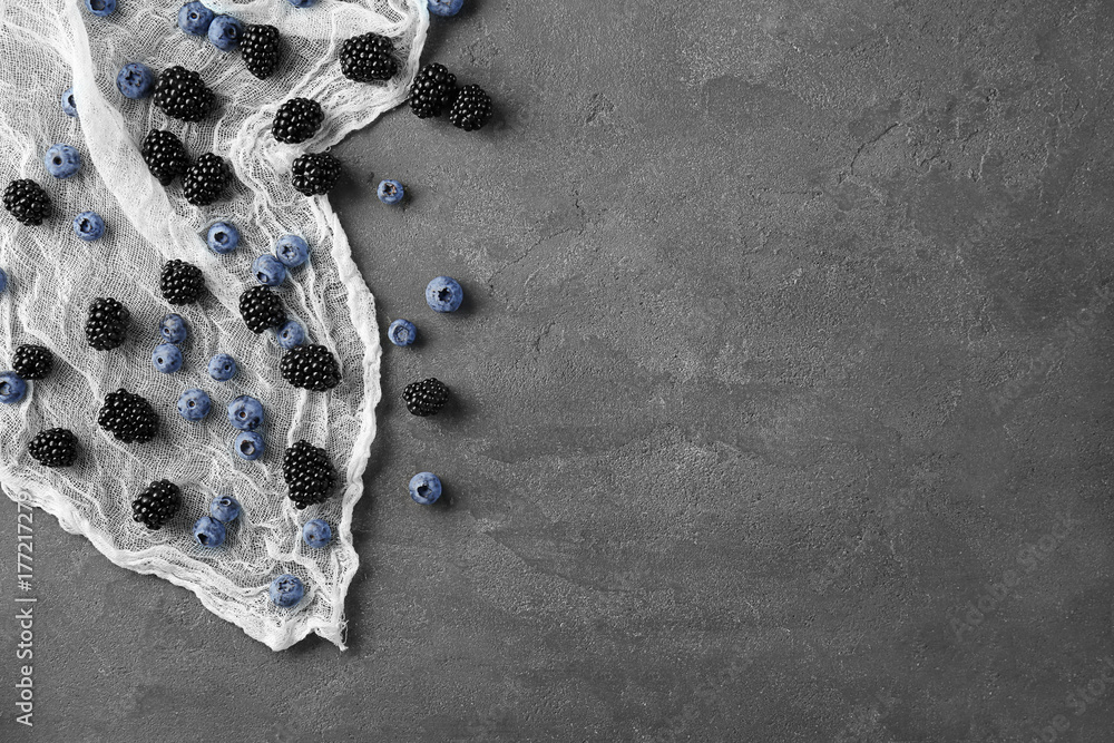 Delicious ripe blackberries and blueberries on grey background