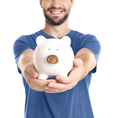 Sticker - Young man with piggy bank on white background