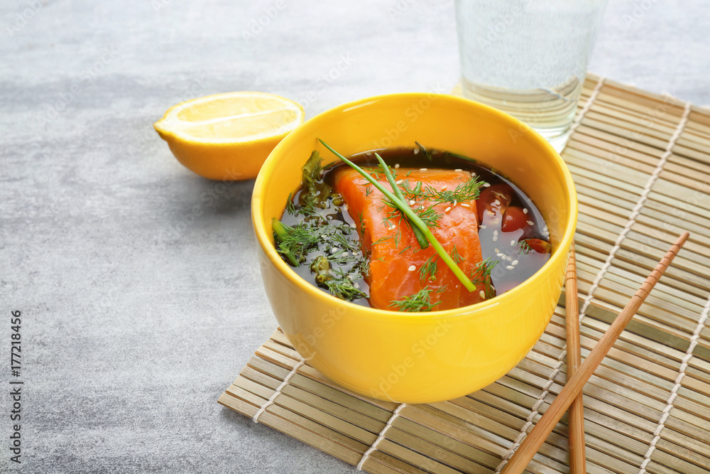 Bowl with delicious salmon on table